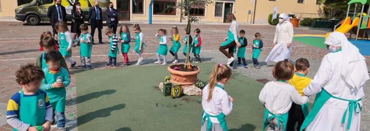 Bambini della Scuola Materna Gresner che festeggiano attorno all'olivo di Redoro appena piantato nella loro scuola